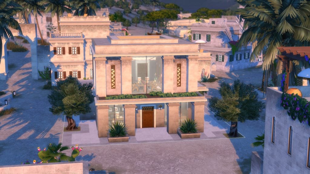 A modern stone home with large glass windows and minimalist landscaping stands in a desert town surrounded by palm trees and neighboring buildings.