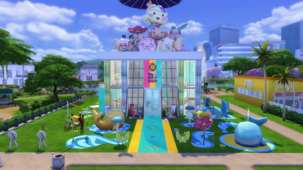 Colorful Sims 4 Gallery build featuring a modern recreation center with giant rooftop plushies, whale fountains and a playful outdoor entrance.